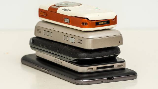 smartphones (used and broken) on white table