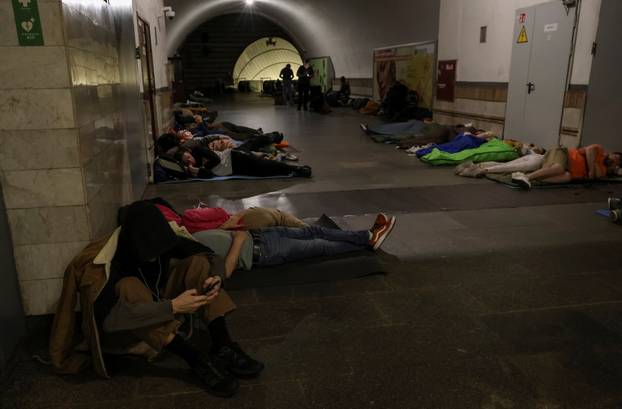 People take shelter inside a metro station during a Russian drone and missile strike in Kyiv