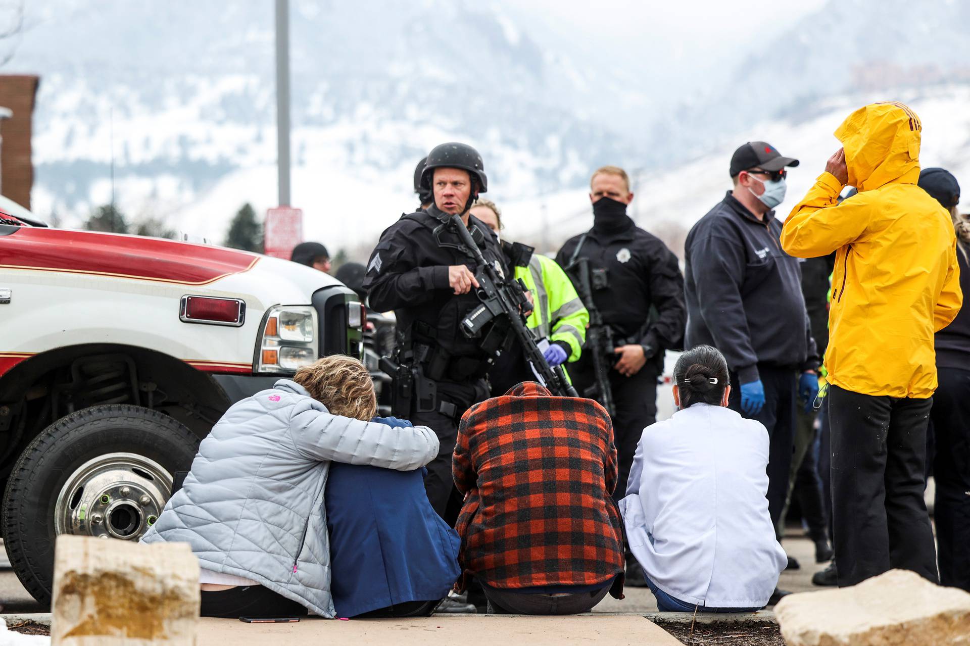 Police guard people evacuated after a call of an active shooter at the King Soopers grocery store in Boulder