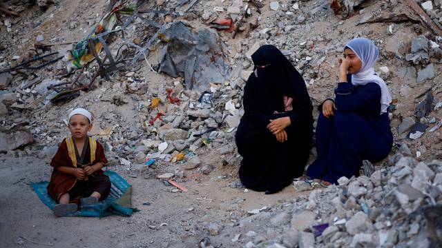 Palestinians hold Eid al-Adha prayers by the ruins of al-Al Rahma mosque destroyed by Israeli air strikes, in Khan Younis, in the southern Gaza strip