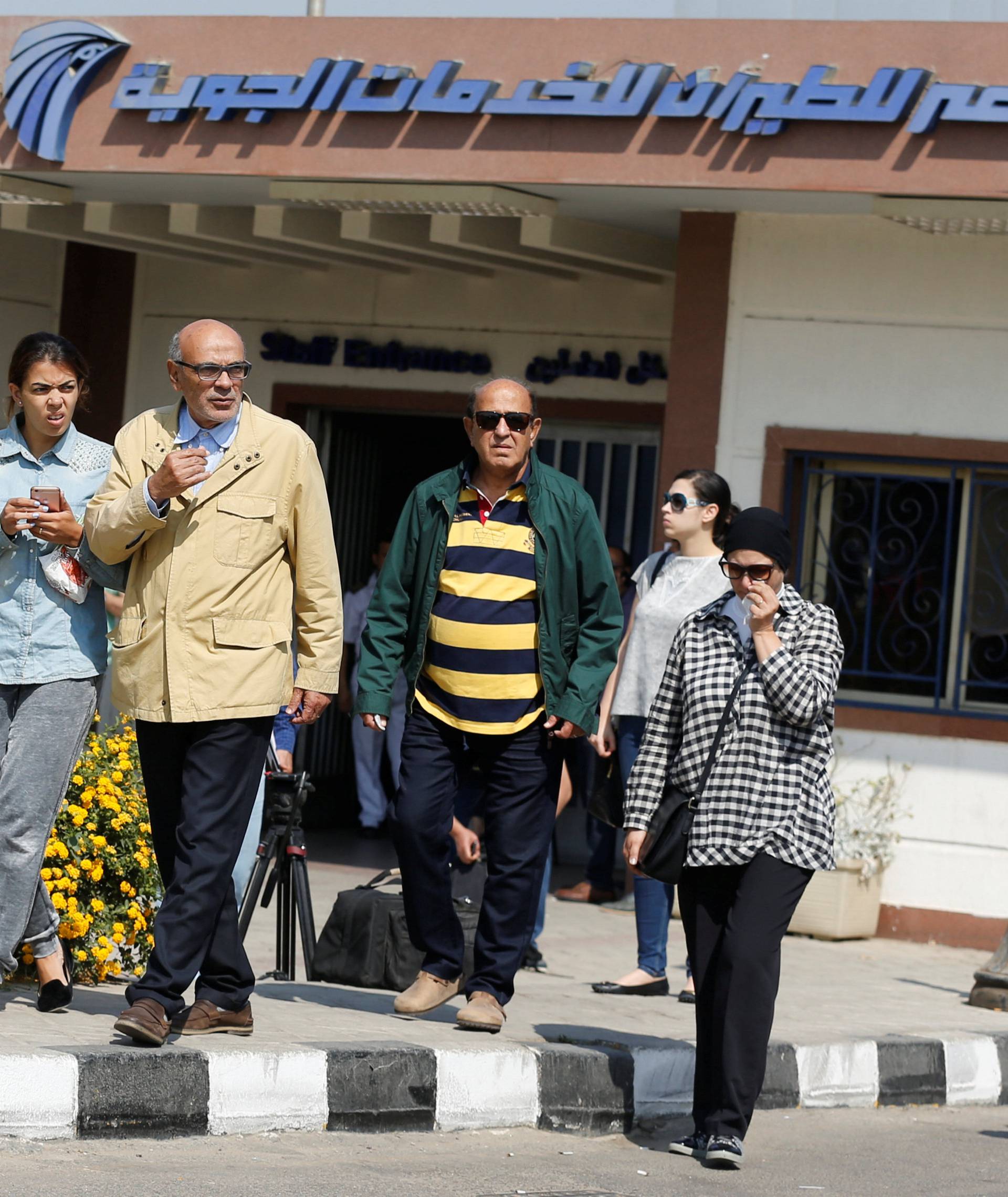 Unidentified relatives and friends of passengers who were flying in an EgyptAir plane wait outside the Egyptair in-flight service building in Cairo