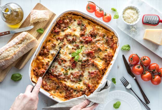 Top,Down,View,Of,A,Freshly,Baked,Lasagna,Being,Cut