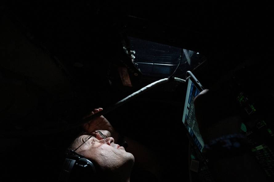 Artemis II Commander Reid Wiseman peers out the window of the Orion spacecraft during the crew’s flyby of the Moon