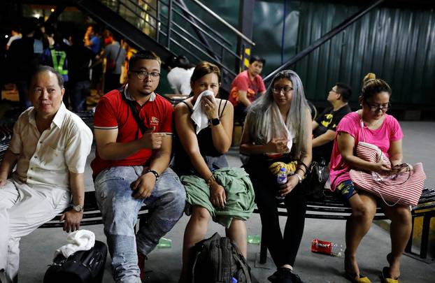 Tourists are pictured after being evacuated from a Resorts World building in Pasay City, Metro Manila, Philippines