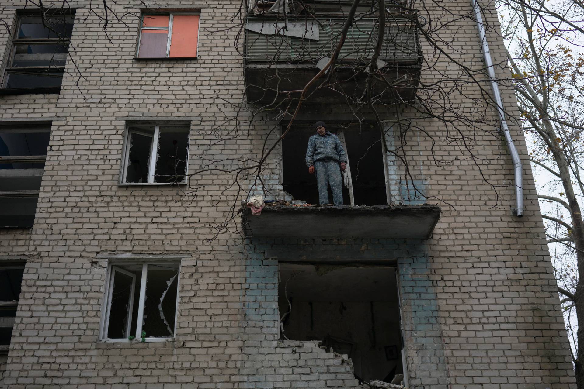 Antonenko, 53, stands on a balcony of his apartment damaged by a recent Russian military strike in Kherson