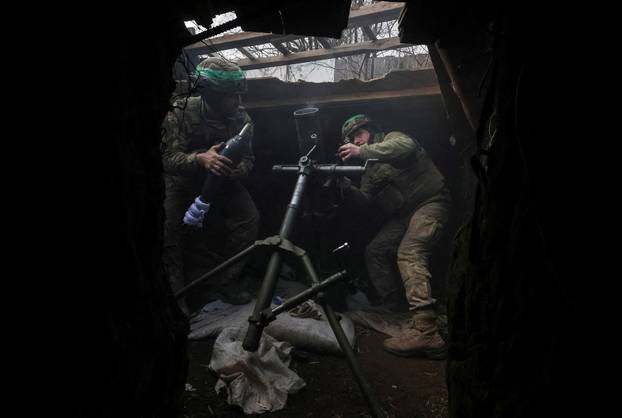 FILE PHOTO: Ukrainian servicemen fires a mortar towards Russian troops at a frontline near the town of Toretsk