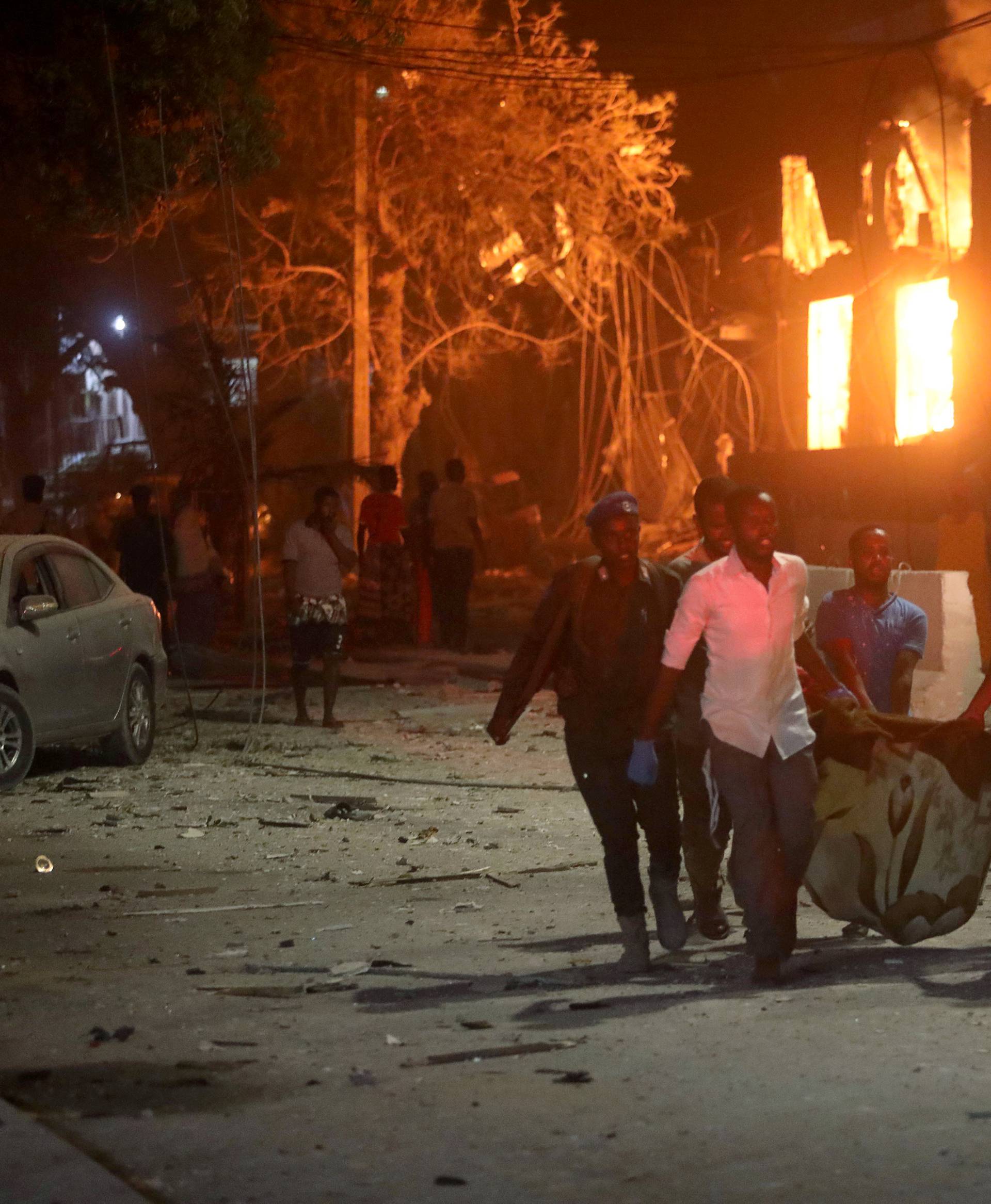 Rescue workers evacuate an injured man from the scene where a suicide car bomb exploded targeting a Mogadishu hotel in a business center at Maka Al Mukaram street in Mogadishu