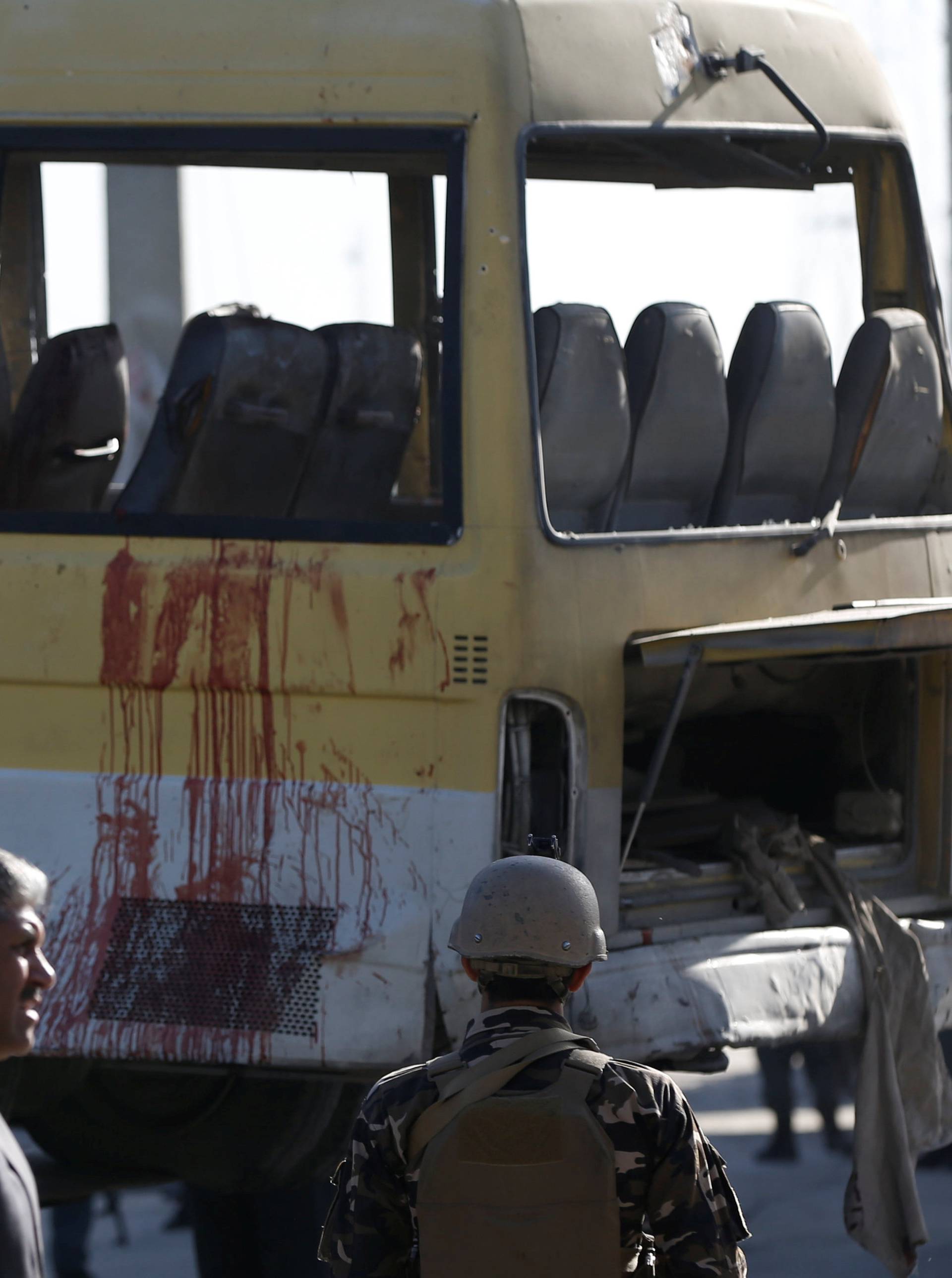 Afghan security forces inspect bloodstains on a minibus that was hit by suicide attacker at the site of an incident in Kabul