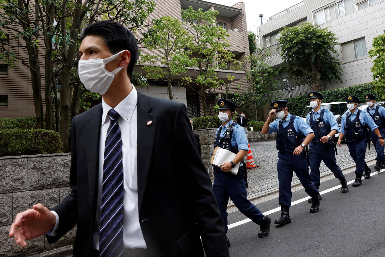 Police officers stand guard before the body of former Japanese Prime Minister Shinzo Abe, who was shot while campaigning for a parliamentary election, arrives at his residence in Tokyo