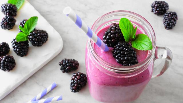 Blackberry smoothie in a mason jar, close up table scene against marble