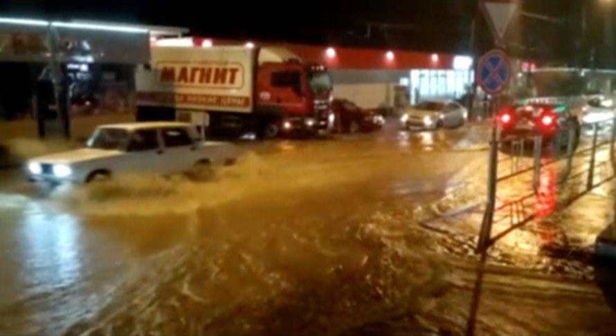 A still image shows vehicles driving along a street in a settlement affected by floodwaters in Krasnodar Region