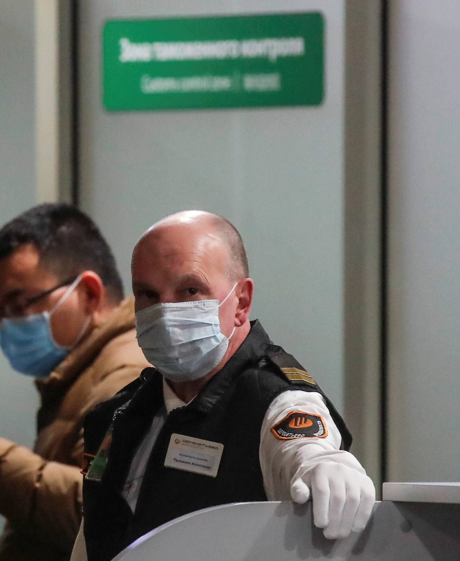 FILE PHOTO: A security service member wearing a mask at Moscow's Sheremetyevo Airport