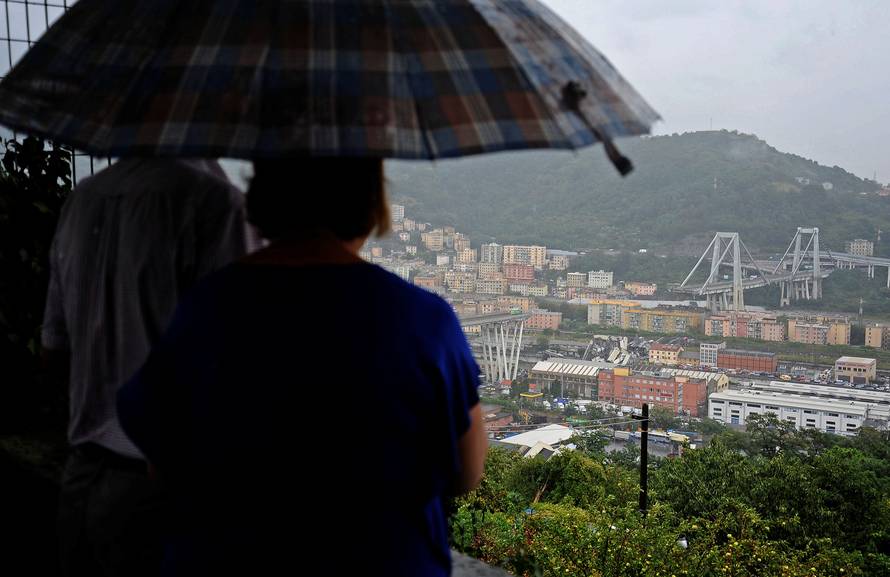 A couple look at the collapsed Morandi Bridge in the Italian port city of Genoa