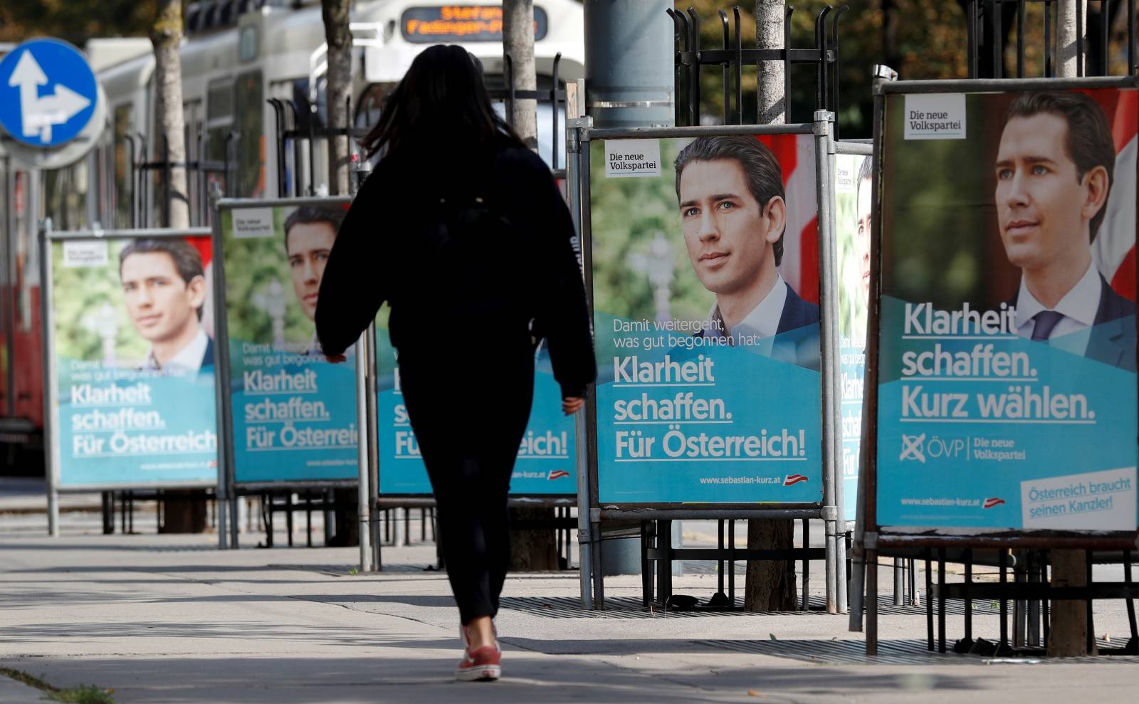A person passes election campaign posters of Austria's Peoples Party in Vienna