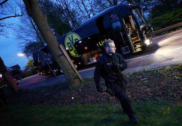 Police with the Borussia Dortmund team bus after an explosion near their hotel before the game