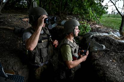 Ukrainian service members observe an area at a position near a frontline in Zaporizhzhia region
