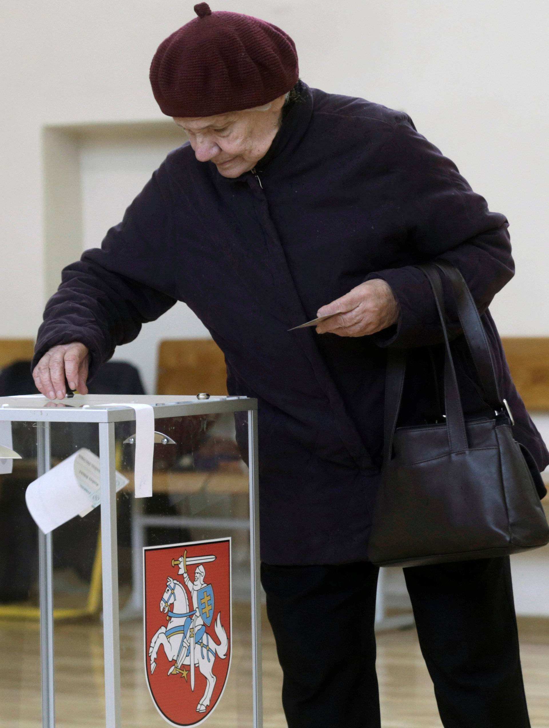 A woman casts her vote during a general election run-off in Birzai