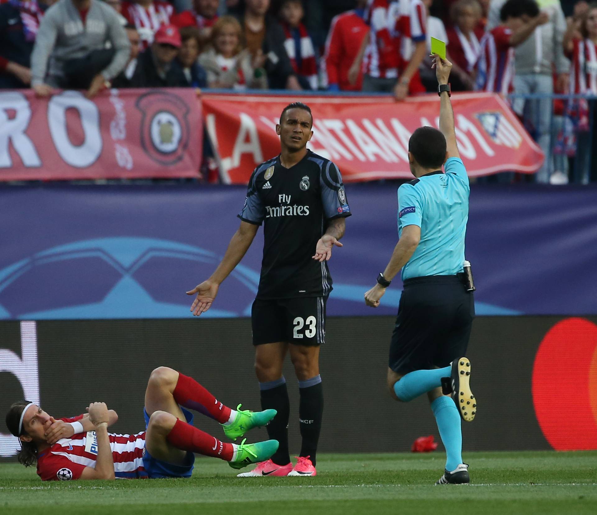 Real Madrid's Danilo is shown a yellow card by referee Cuneyt Cakir for a foul on Atletico Madrid's Filipe Luis