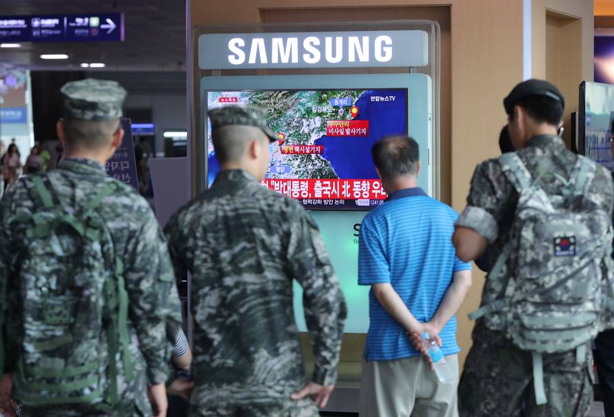 South Korean soldiers and passenger watch a TV broadcasting a news report on Seismic activity produced by a suspected North Korean nuclear test, at a railway station in Seoul