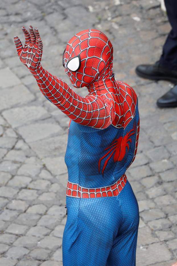 A person dressed as Spiderman wave, as he stands amongst the faithful listening to Pope Francis at the Vatican