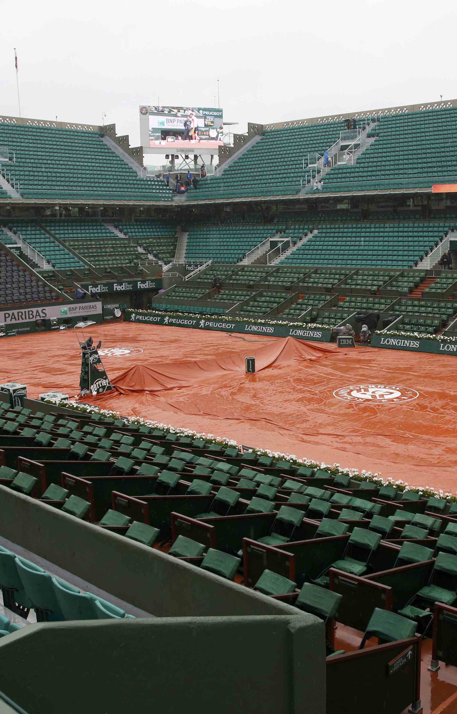Tennis - French Open - Roland Garros - A tarpaulin covers the central court 