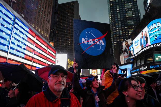 People watch on a video screen as the spaceship InSight lands on Mars surface after a six-month journey, in Times Square in New York