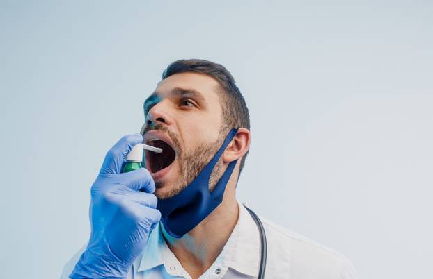 European male doctor use inhaler in studio