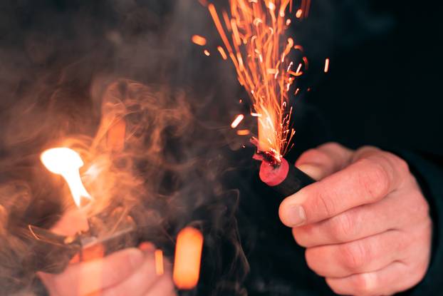 Firecracker Burning in Hand with Sparks and Smoke