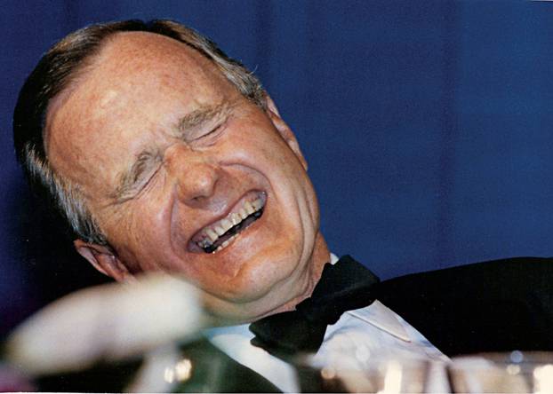 FILE PHOTO: U.S. President George H.W. Bush laughs while attending the annual White House Correspondents Association Awards dinner in Washington