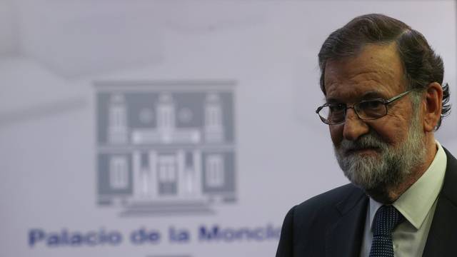 Spain's PM Rajoy leaves the conference room after delivering a statement at the Moncloa Palace in Madrid