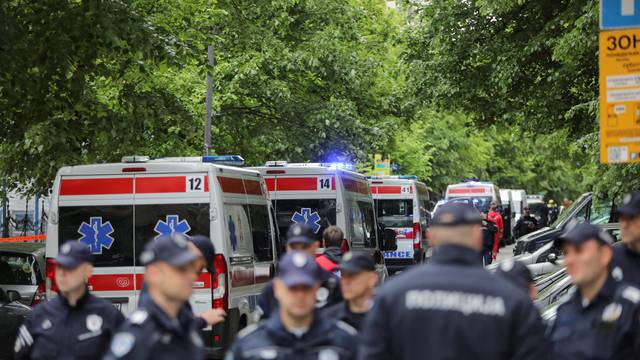 Police officers secure the area after a 14-year-old boy opened fire on other students and security guards at a school in downtown Belgrade