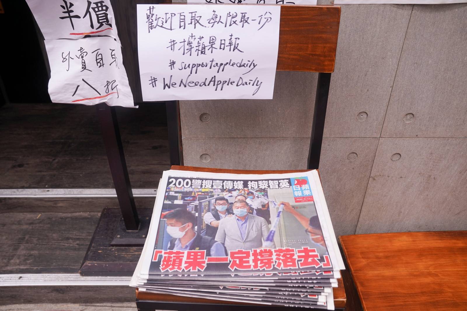 Copies of the Apple Daily newspaper with the headline "Apple Daily will fight on", are seen outside a restaurant in Hong Kong