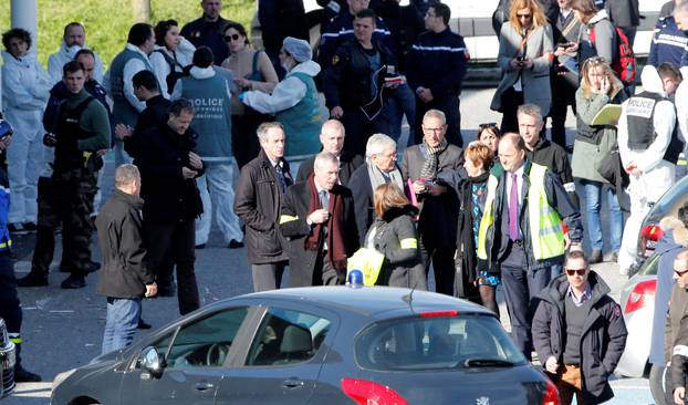 Police officers and investigators are seen in front of a supermarket after a hostage situation in Trebes