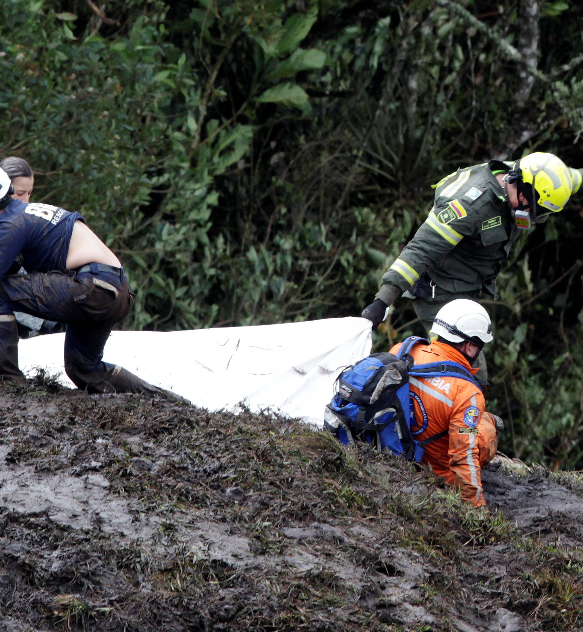 Rescue workers carry the body of a victim from a plane that crashed into the Colombian jungle with Brazilian soccer team Chapecoense onboard, near Medellin