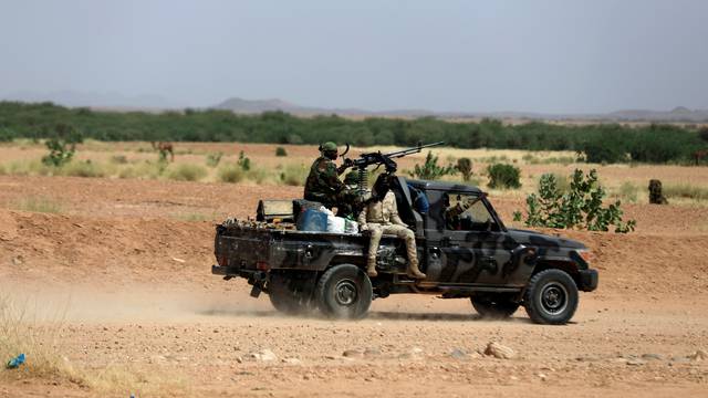 FILE PHOTO: Nigerian army soldiers board a pickup to escort Nigerians heading north towards Libya as they leave Agadez