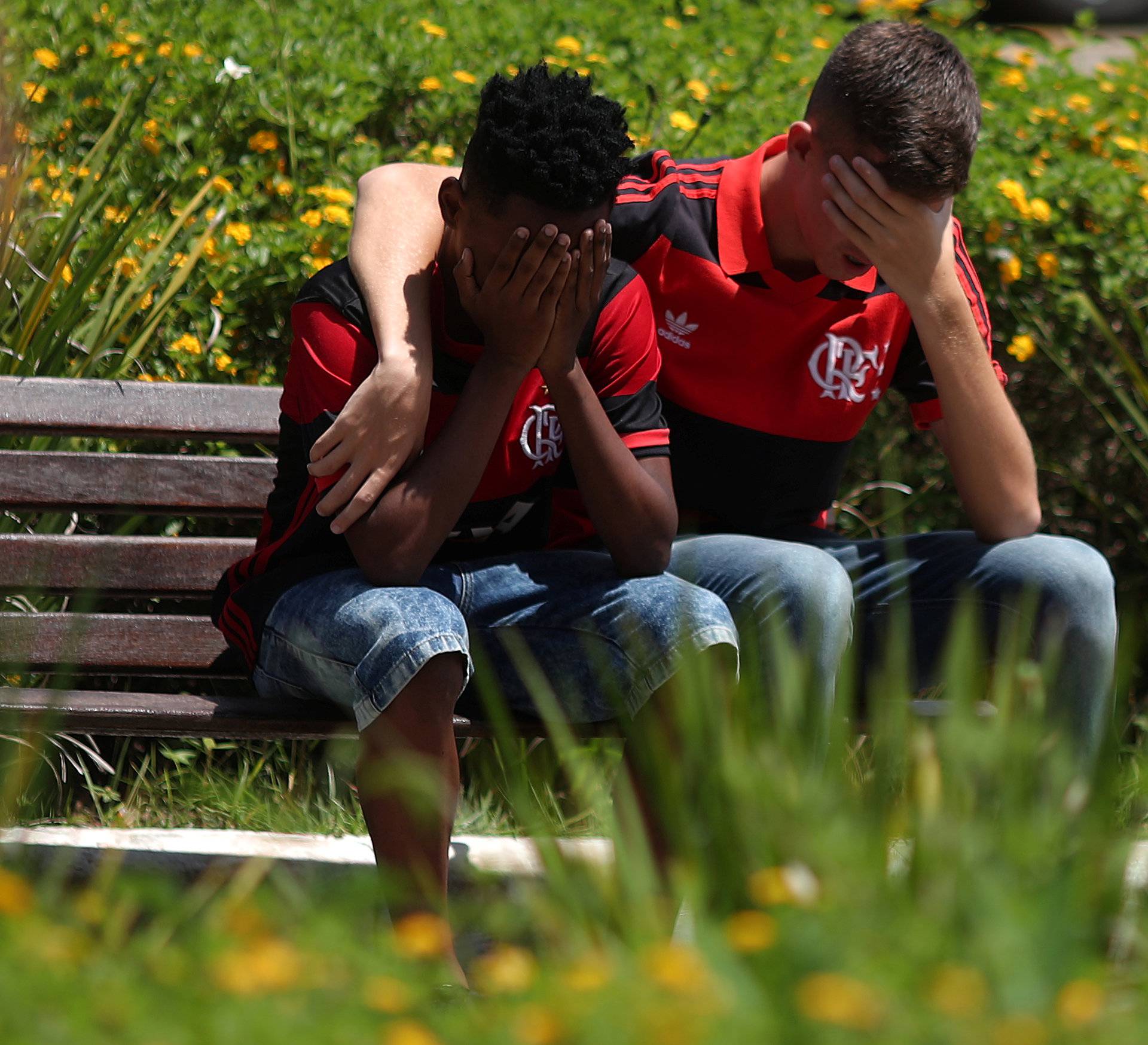 Friends of Vinicius de Barros Silva Freitas, mourn during his burial, after a deadly fire at the Flamengo soccer club's training center, in Volta Redonda