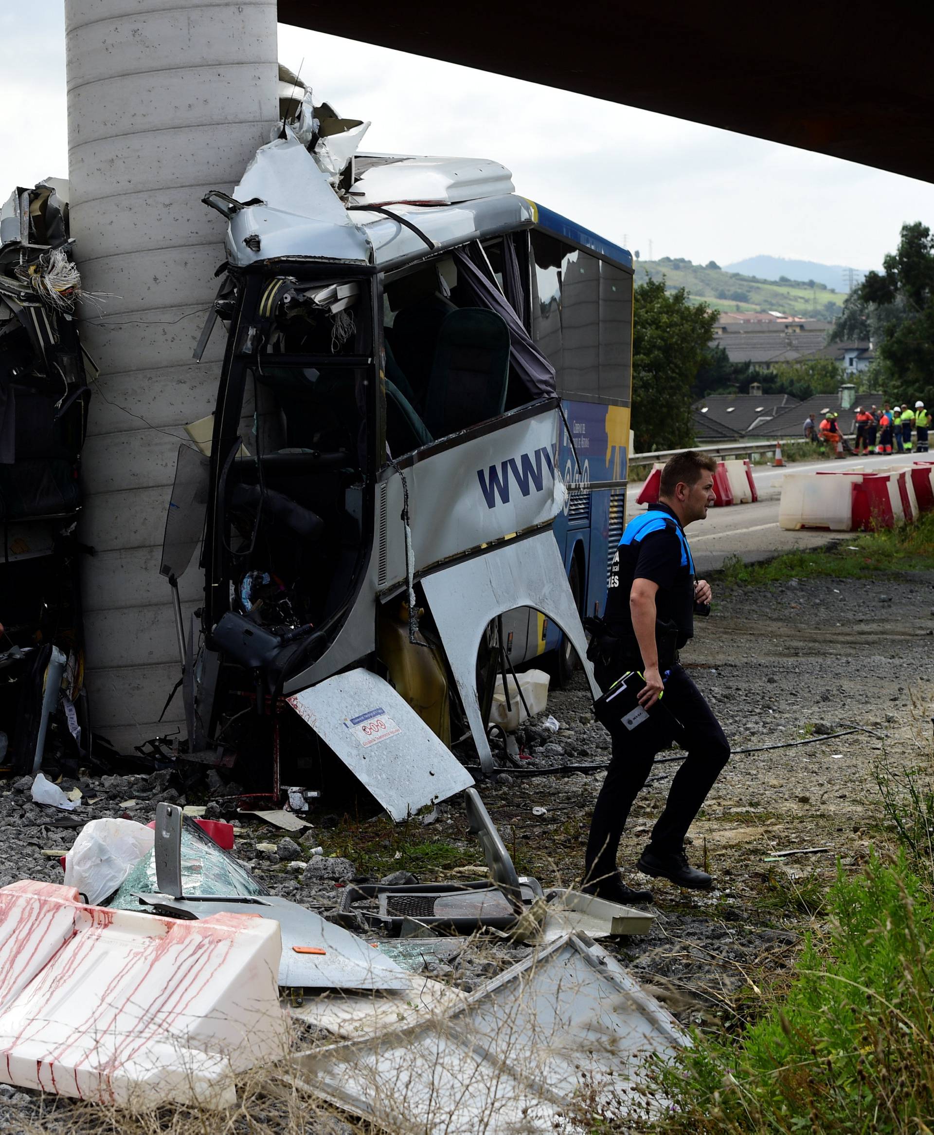 Police investigators survey the wreckage of a bus crash which left at least four people dead in Aviles
