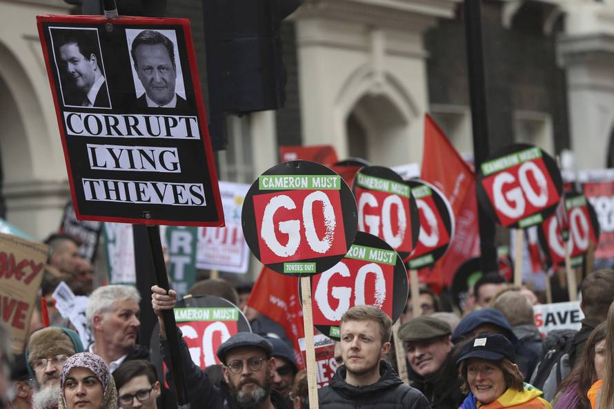 Demonstrators hold placards during an anti-austerity protest in London