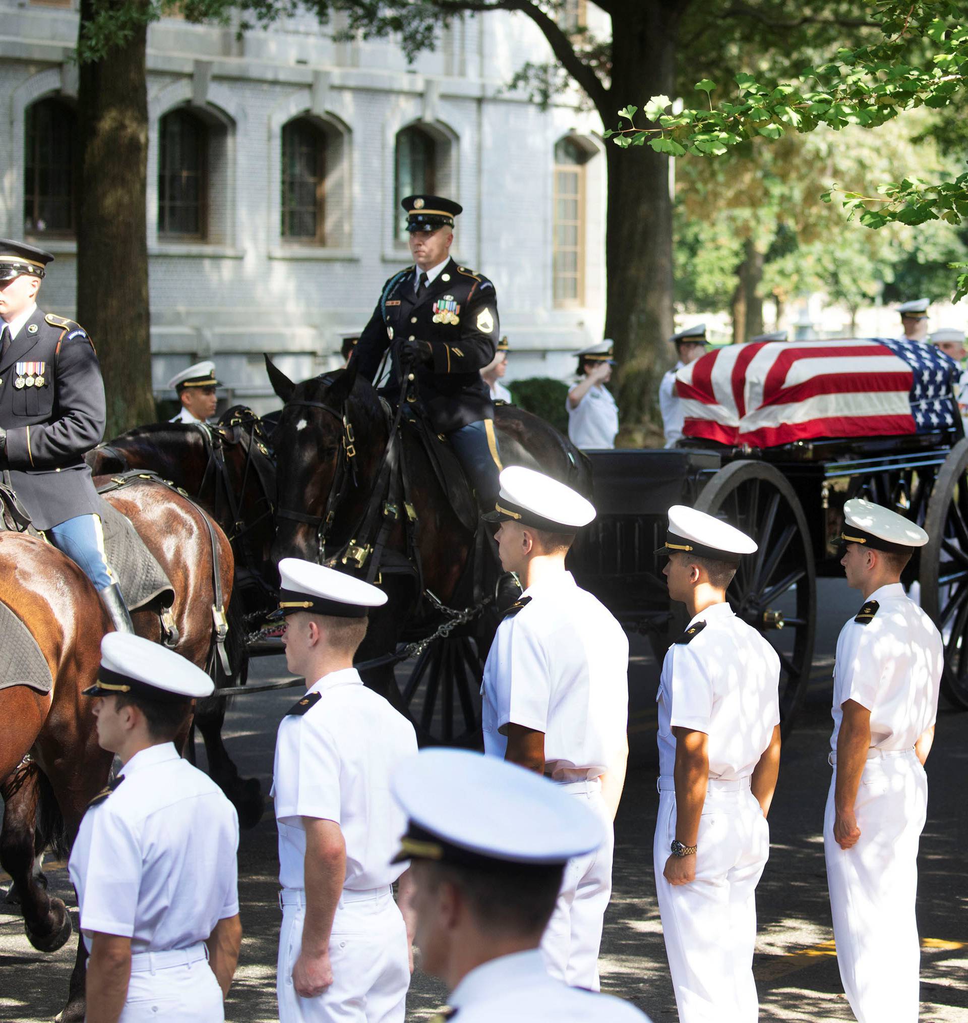 The horse drawn caisson bearing the body of Sen. McCain moves through the grounds of the United Sates Naval Academy in Annapolis