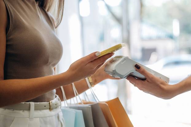 Worker,Is,Holding,The,Terminal.,Woman,Is,Paying,For,Clothes,