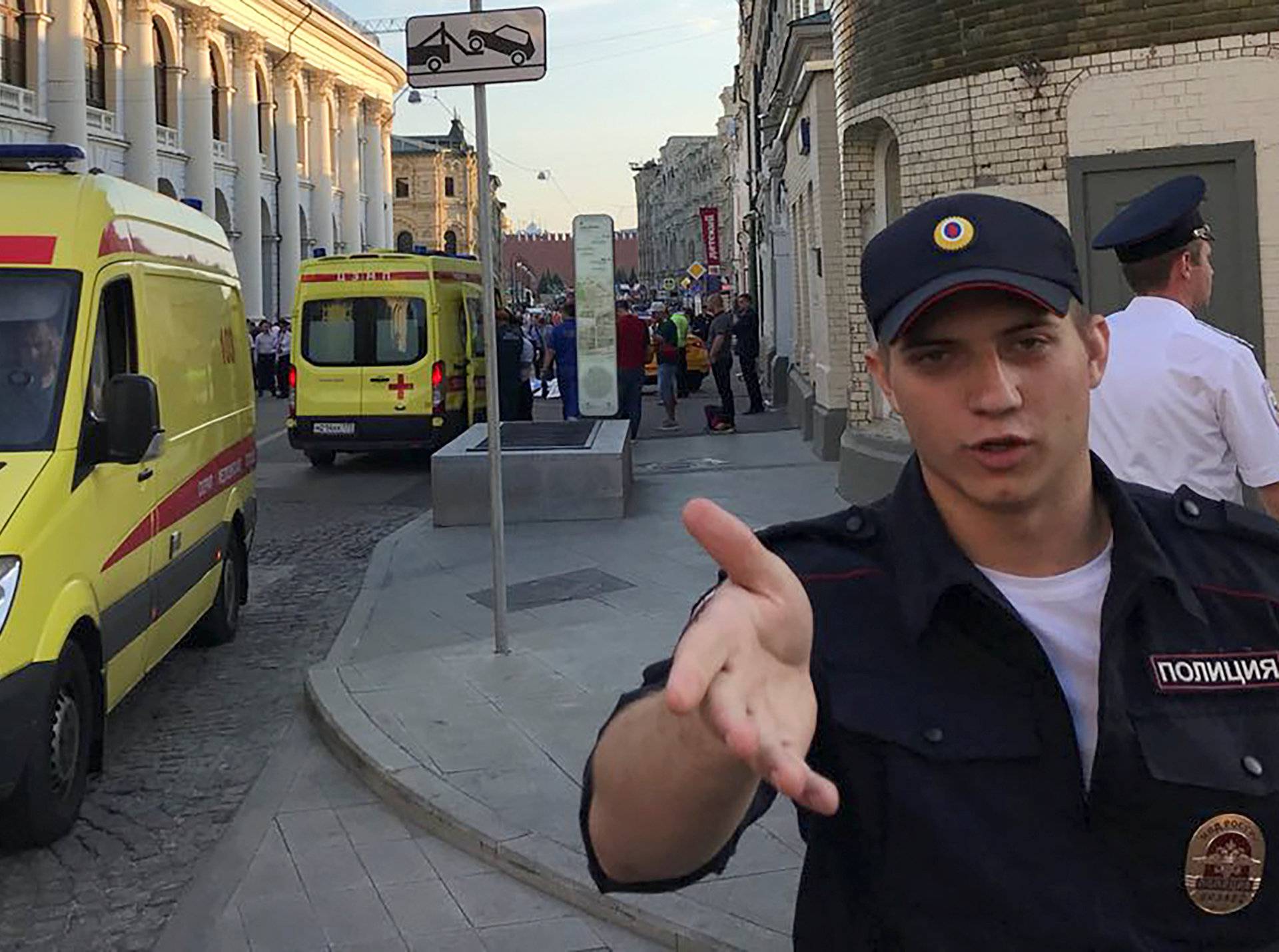 A police officer blocks the way as ambulances are parked near a damaged taxi, which ran into a crowd of people in central Moscow