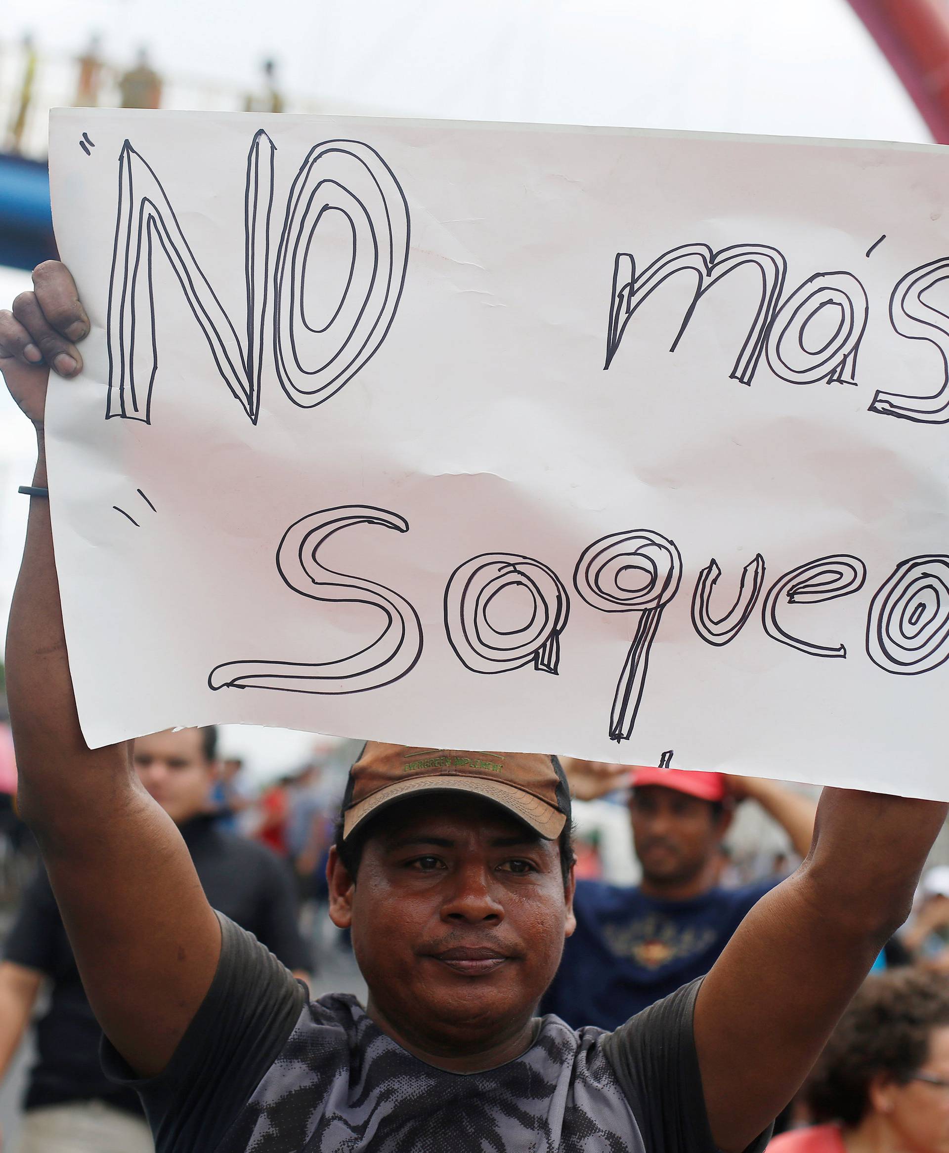 A man holds up a placard reading "No more looting" following protests over a reform to the pension plans of the INSS in Managua
