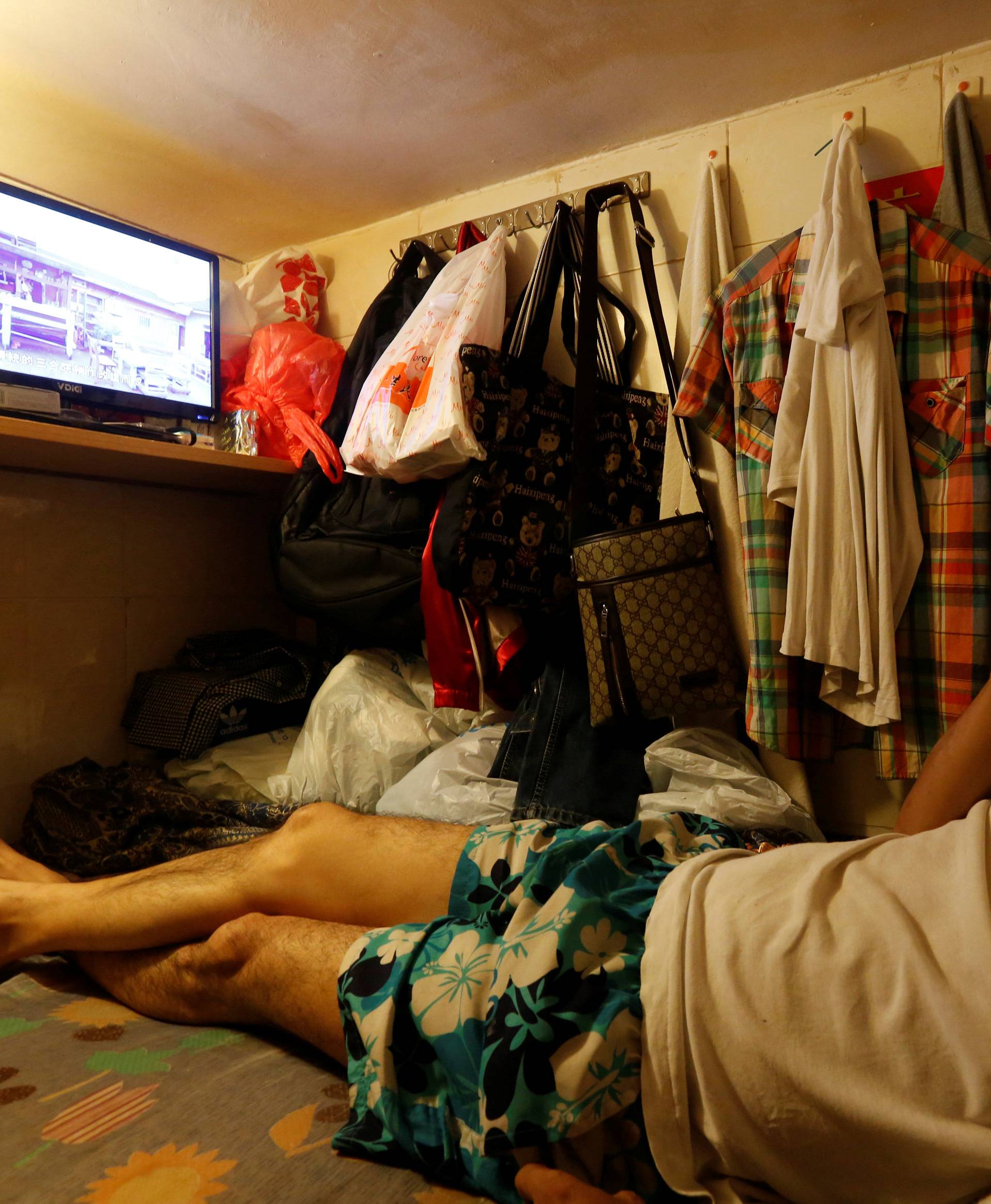 Unemployed Hong Kong resident Simon Wong, 61, watches TV inside his 4-by-6-feet partitioned unit, or "coffin unit", with a monthly rent of HK$1,750 ($226) in Hong Kong