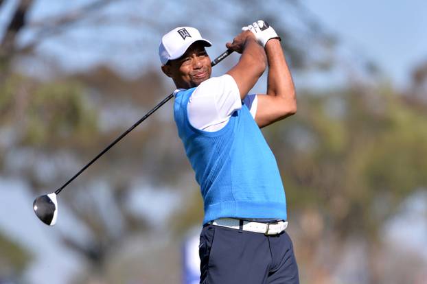 FILE PHOTO: Tiger Woods tees off the 5th hole during the first round of the Farmers Insurance Open golf tournament in La Jolla