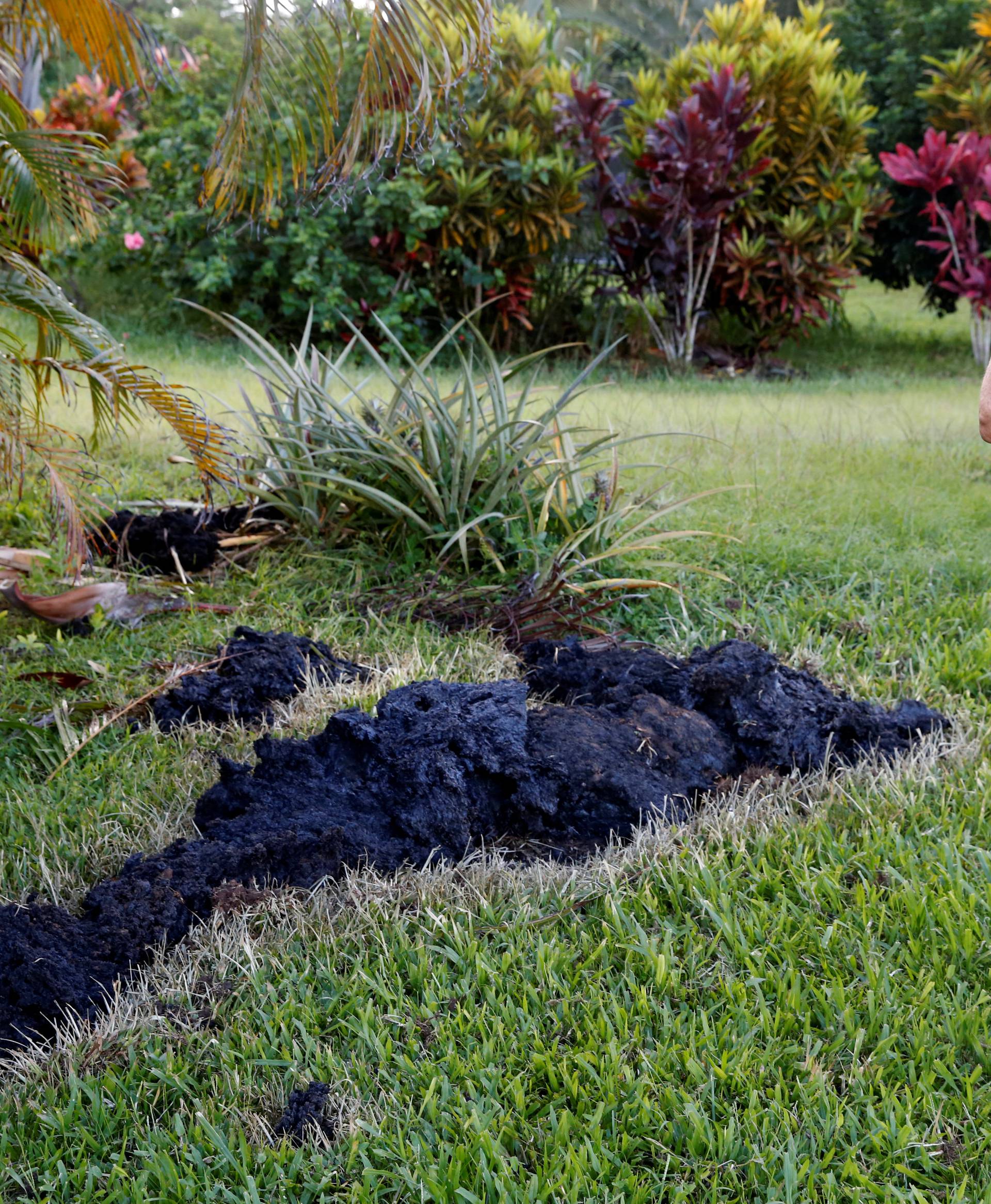 Patricia Spinoza, of Puna, takes a photo of lava on a lawn  on the outskirts of Pahoa