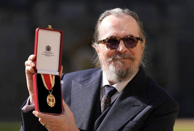 Actor Gary Oldman poses after being made a Knight Bachelor at an investiture ceremony at Windsor Castle