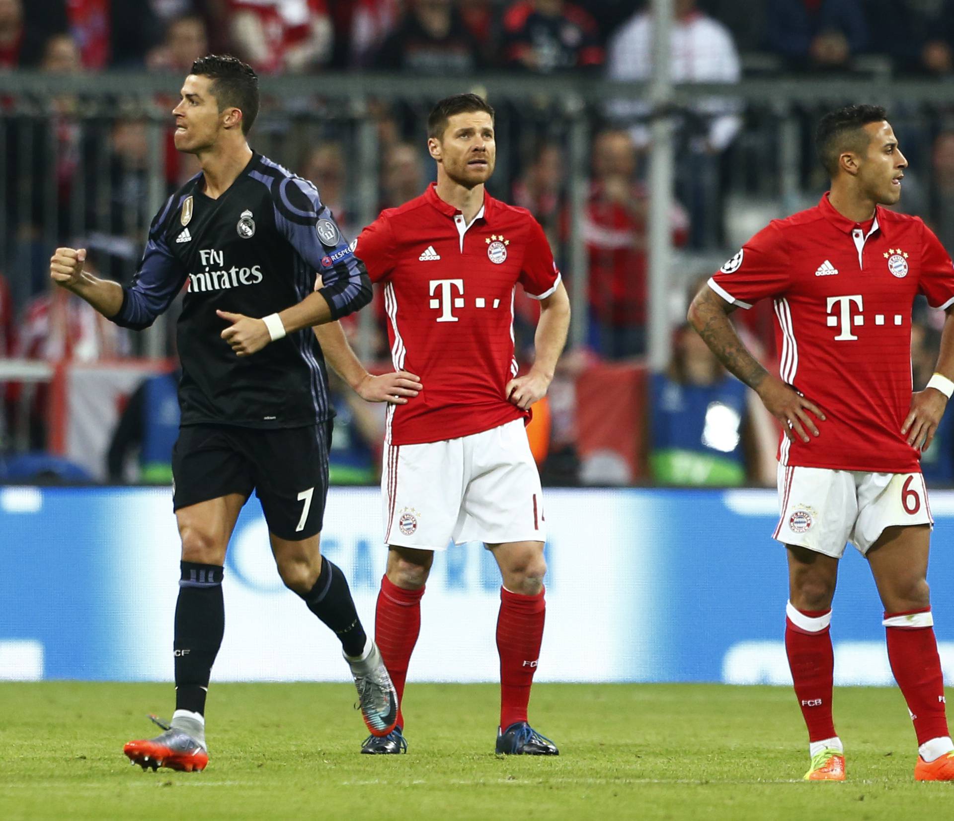 Real Madrid's Cristiano Ronaldo celebrates scoring their first goal as Bayern Munich's Xabi Alonso and Thiago Alcantara look dejected