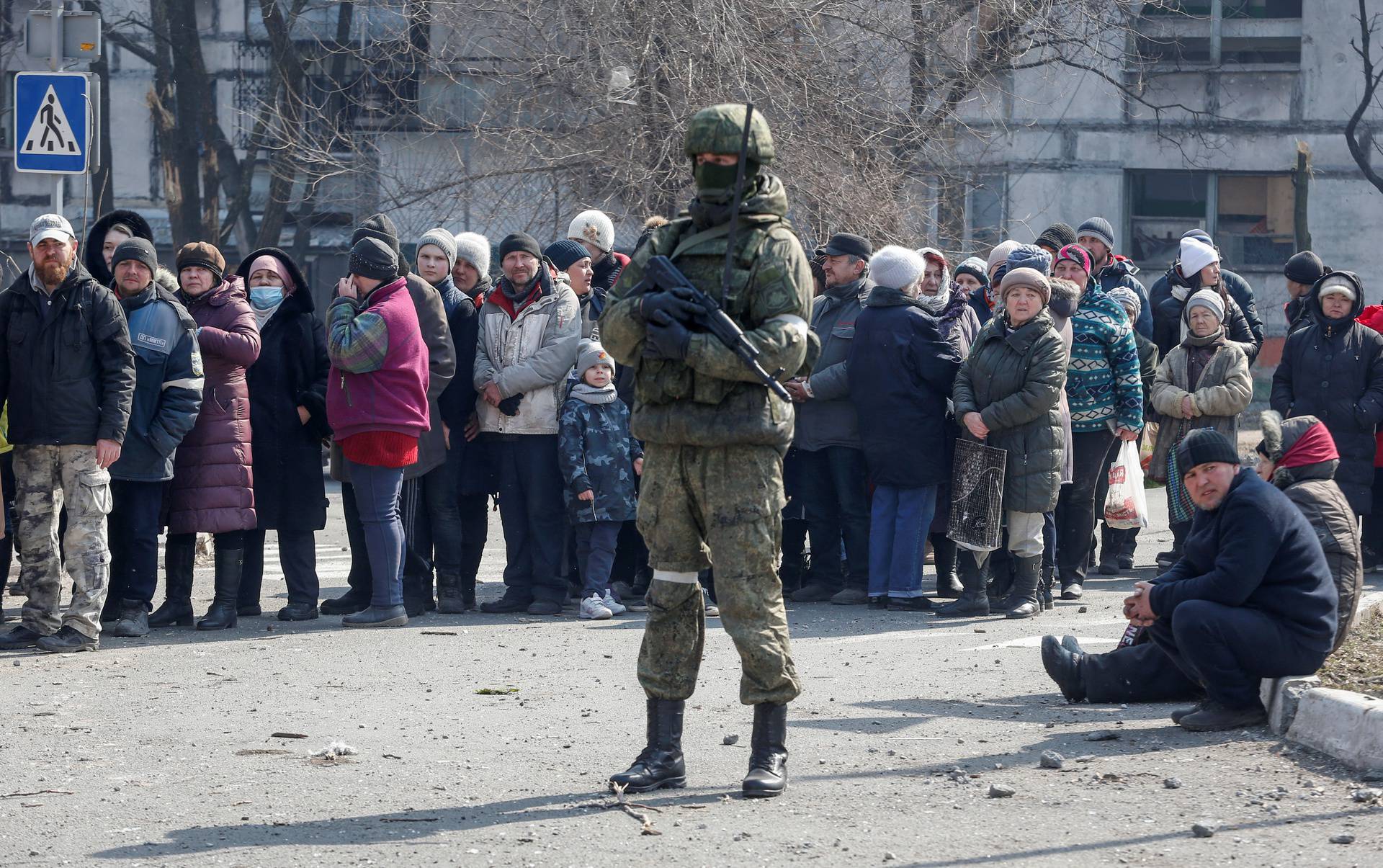 Local residents queue for humanitarian aid in the besieged southern port of Mariupol