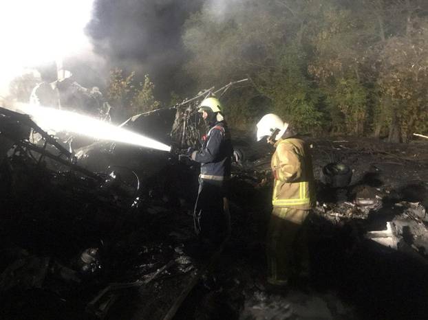 Rescuers work at the crash site of the Ukrainian military Antonov An-26 plane outside of Chuhuiv town