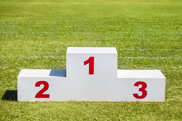 White wooden winner podium placed on green grass sport field on 